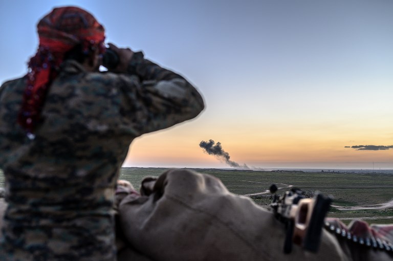 LAST REDOUBT. A Syrian Democratic Forces fighter uses a binocular to inspect the embattled village of Baghouz in Syria's northern Deir Ezzor province on February 19, 2019. File photo by Bulent Kilic/AFP  