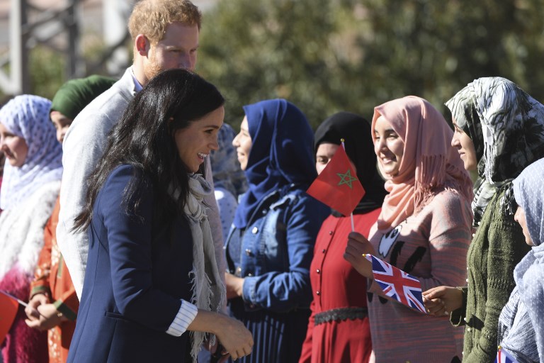 MOROCCO VISIT. Prince Harry (L) , Duke of Sussex, and Meghan, Duchess of Sussex, greet young girls on February 24, 2019, in the town of Asni on the foothills of the High Atlas mountains. Photo by Fadel Senna/AFP 