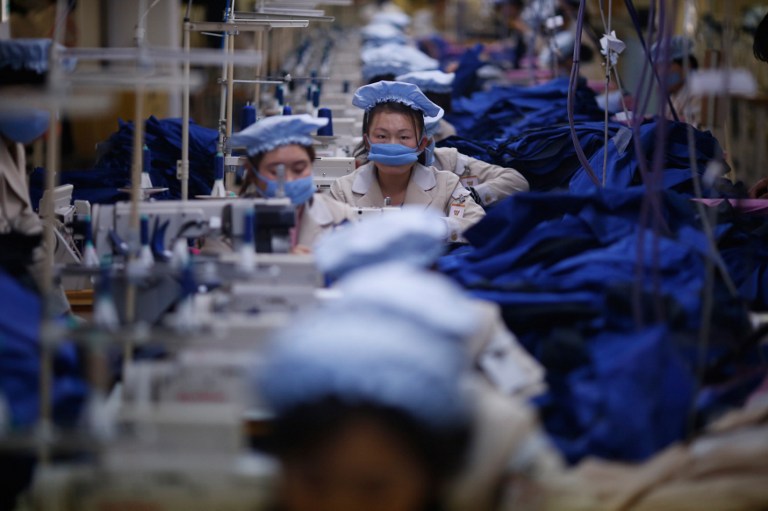 In this file photo, North Korean employees work at a factory of a South Korean-owned company at the Joint Industrial Park in Kaesong on December 19, 2013. Kim Hong-Ji/Pool/AFP 