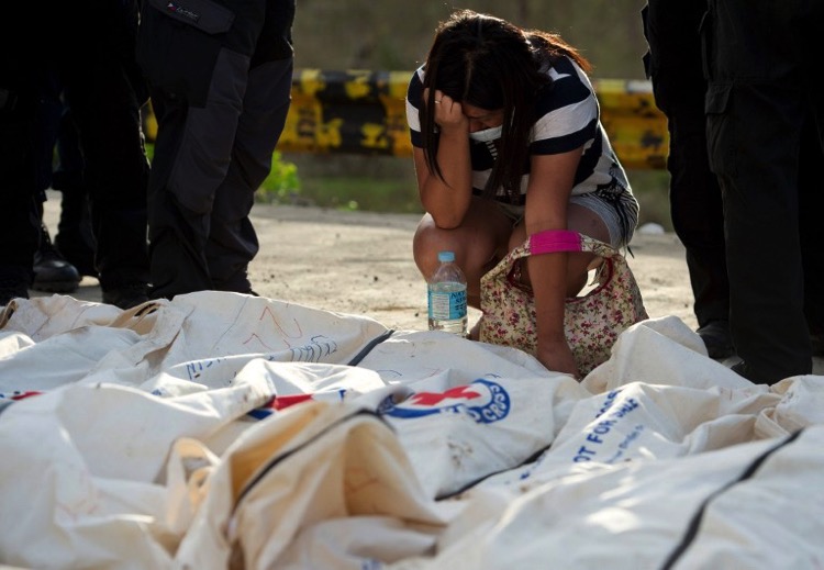 In this file photo taken on November 19, 2013, a mother reacts as she finds her missing 6-year-old son among the bodies brought to one of three mass burial sites in Tacloban where they received more than one thousand victims after Super Typhoon Haiyan swept over the central Philippines. AFP PHOTO / ODD ANDERSEN / FILES