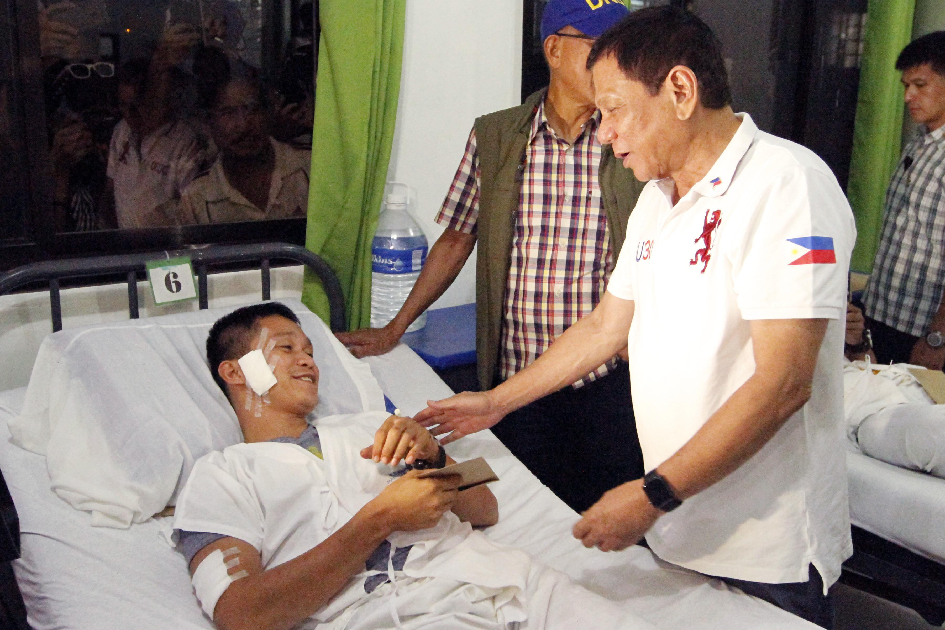TRIBUTE TO THE WOUNDED. President Rodrigo Duterte visits a wounded soldier at Camp Navarro General Hospital in Zamboanga City on July 22, 2016. Photo by Benjamin Basug/NIB  