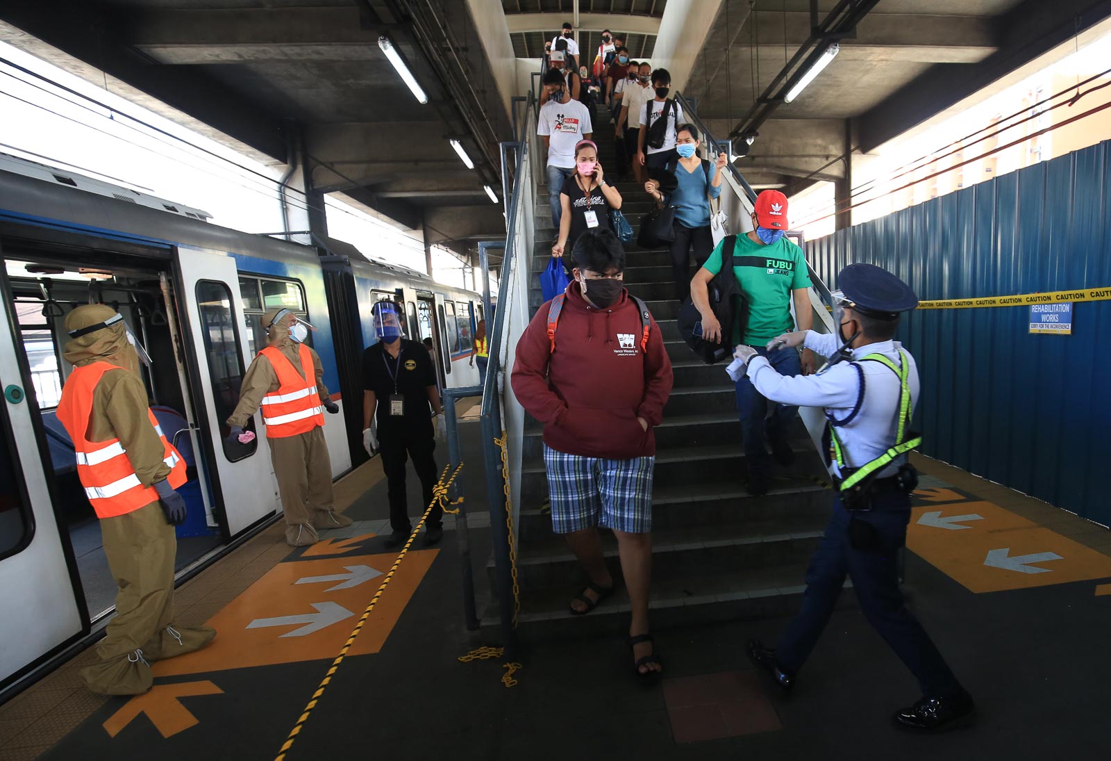 LIMITED OPERATIONS. Workers sanitize and disinfect the seats and handrails before letting commuters in the coaches at the MRT3 Taft Station in Pasay City following the resumption of operation of the train systems in Metro Manila under the general community quarantine on June 1, 2020. Photo by Ben Nabong/Rappler 