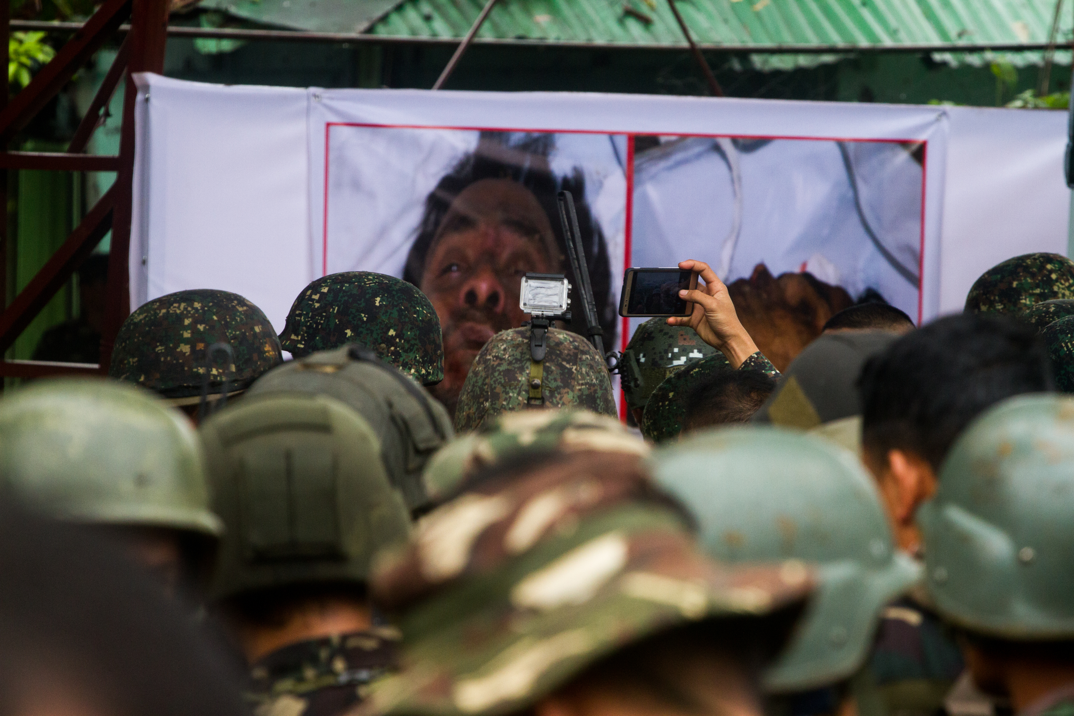 KILLED. Troops stare at enlarged photos of the dead bodies of terror leadres Isnilon Hapilon and Omar Maute  