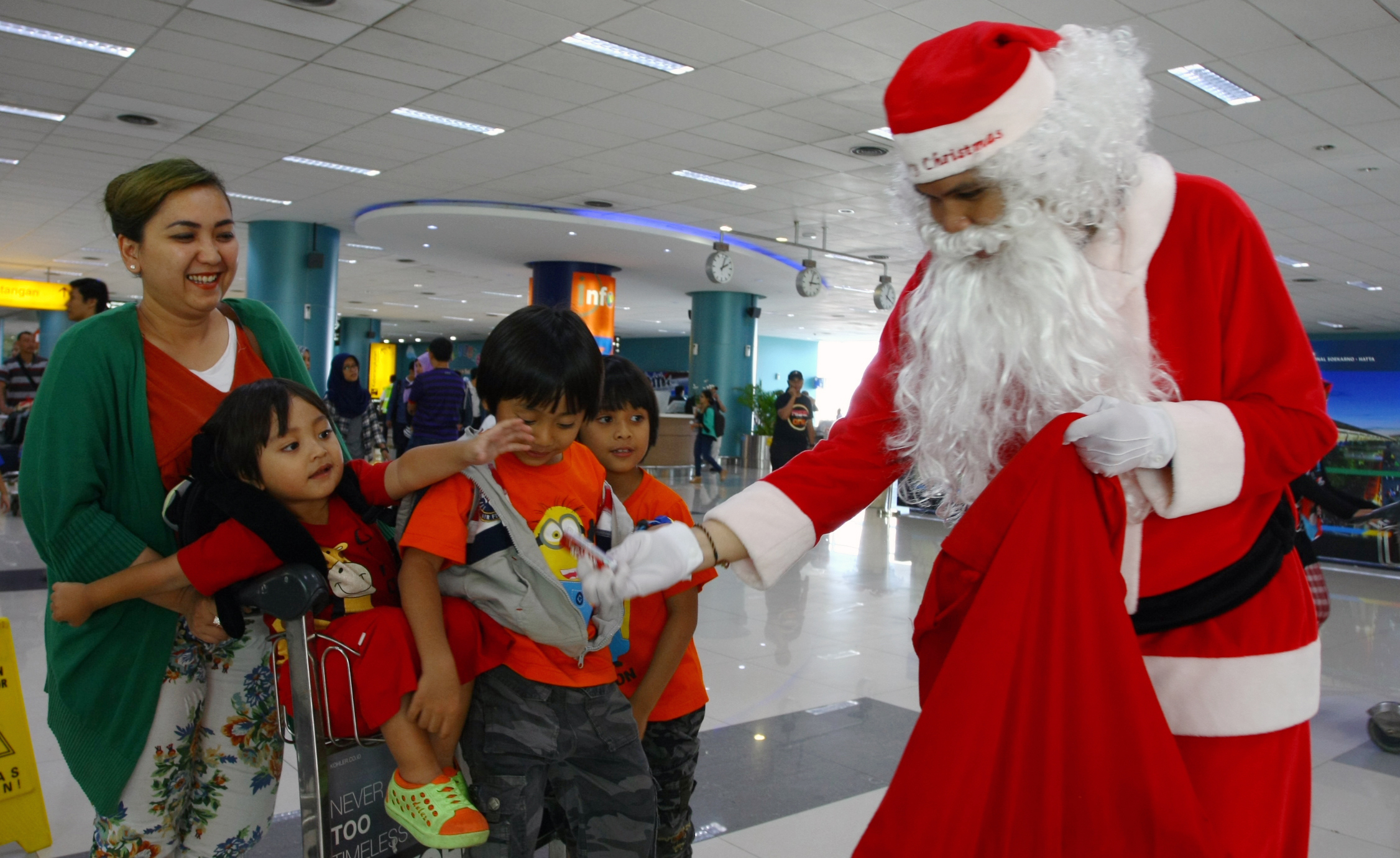 Sinterklas membagikan coklat kepada anak calon penumpang pesawat yang akan berangkat di Terminal 3 Bandara Soekarno-Hatta, Tangerang, Banten, pada 22 Desember 2015. Foto oleh Muhammad Iqbal/Antara 
