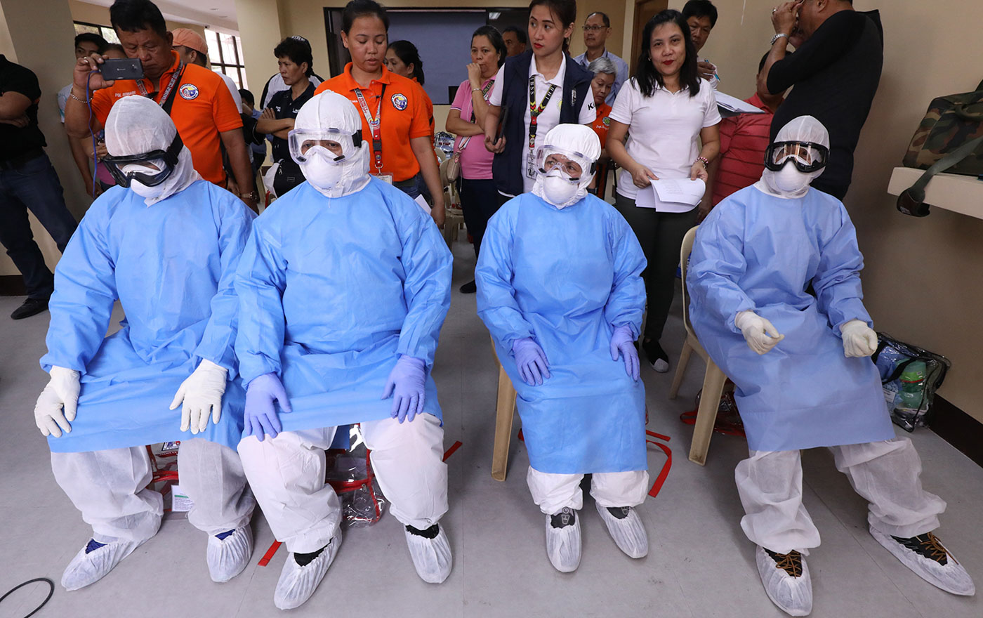 PROTECTION. The Quezon City Disaster Risk Reduction and Management Office
on March 5, 2020, demonstrates to barangay first responders how to use the protective
gear properly in case COVID-19 hit their barangays. File photo by Darren Langit/Rappler  