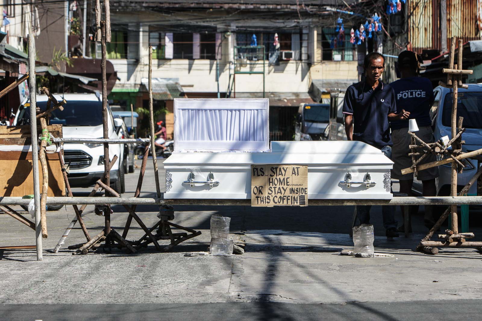 STAY HOME. Officers of Brgy. 436 in Sampaloc, Manila on April 3, 2020, set up a checkpoint with a coffin on display bearing a sign, 'Stay Home or Stay Inside this Coffin' serving as a stern warning to residents during the implementation of the enhanced community quarantine. Photo by Ben Nabong/Rappler  