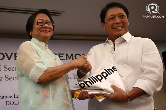 DOLE. Outgoing Secretary Rosalinda Baldoz hands over the agency flag to newly-installed Department of Labor and Employment (DOLE) Secretary Silvester Bello III during a short turnover ceremony at the DOLE main office in Intramuros. Photo by Ben Nabong/Rappler  
