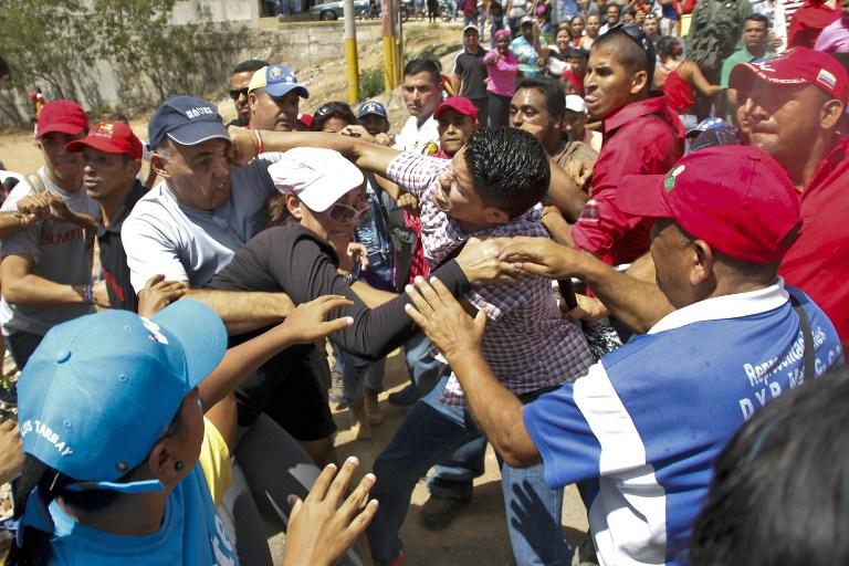 Venezuelan Government' supporters (R) clash against President Maduro opponents during a demonstration to demand a recall referendum against Maduro on October 12, 2016 in Margarita islan, Venezuela. Stringer/AFP 