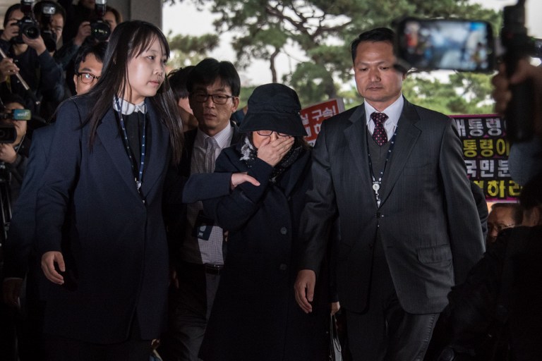 Choi Soon-Sil (C) is escorted as she arrives at the Seoul Central District Prosecutor's Office in Seoul on October 31, 2016. Ed Jones/AFP 
