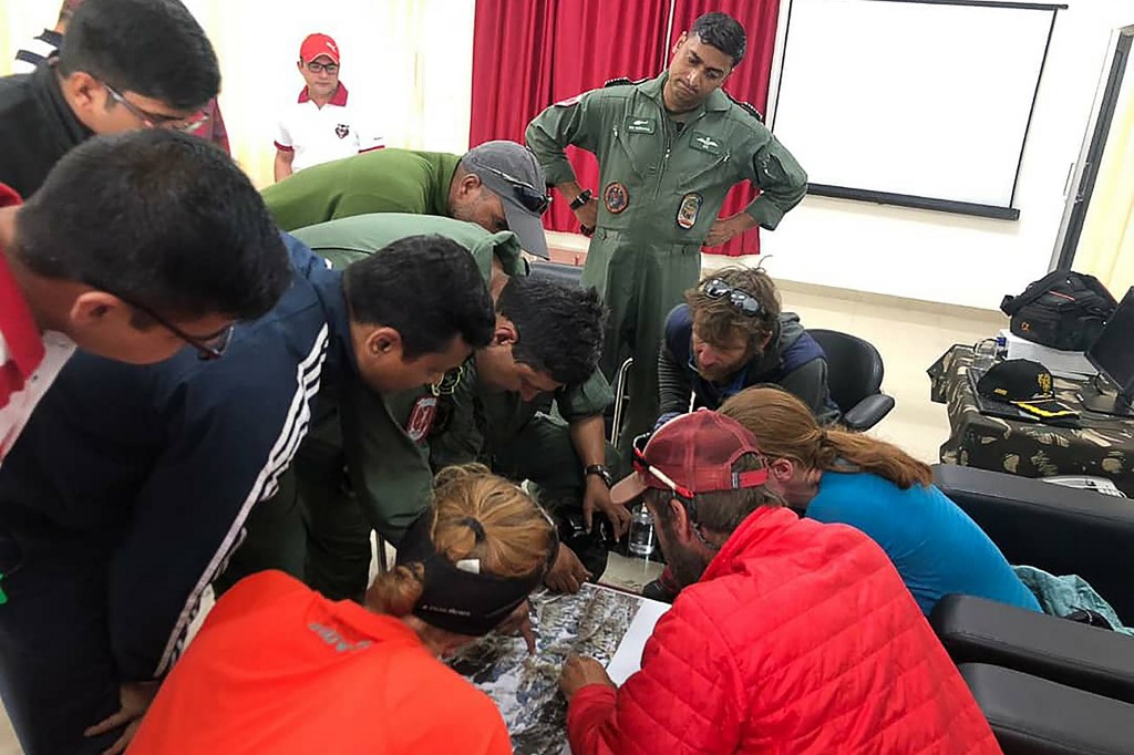 AERIAL VIEW. In this handout photo released by the Indo-Tibetan Border Police on June 3, 2019, rescued mountaineers look at a an aerial picture along with rescue personnel upon arriving to a Indo-Tibetan Border Police camp in Pithoragarh after being rescued following an avalanche while climbing the Nanda Devi in the northern Indian state of Uttarakhand in India. AFP PHOTO / Indo-Tibetan Border Police 