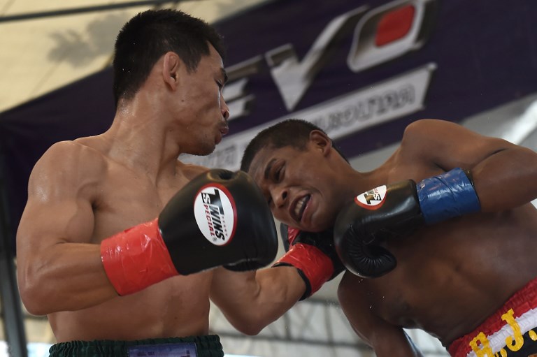 UNDEFEATED. Thai boxer Wanheng Menayothin (left) lands a blow against Panamanian challenger Leroy Estrada to retain his WBC minimumweight title. Photo by Lillian Suwanrumpha/AFP  