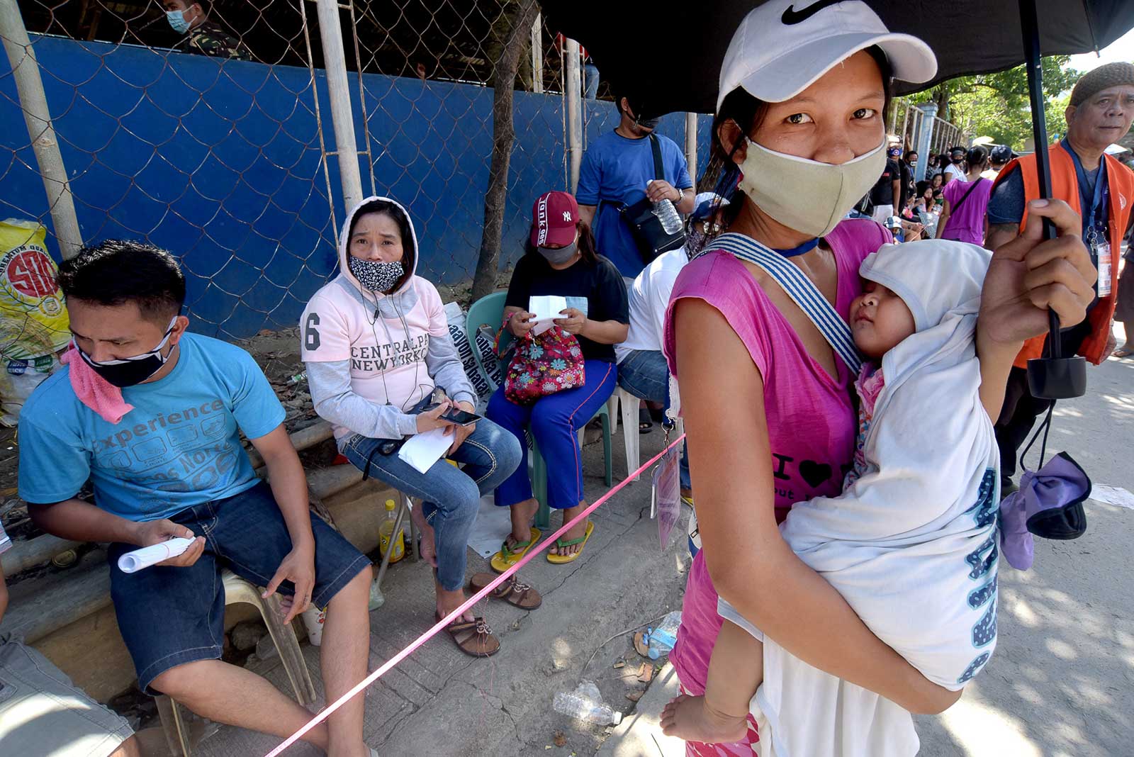 SUBSIDY PROGRAM. A mother and her 7-month-old son wait for the distribution of the government's emergency subsidy program on May 12, 2020 at Barangay San Jose in Rodriguez, Rizal. File photo by Angie de Silva/Rappler  
