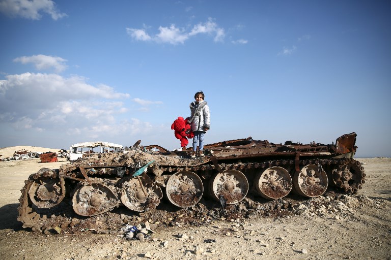 CHILD OF WAR. Eleven-year-old Syrian girl Rawan poses on a destroyed tank with her stuffed bear near the village of Yazi Bagh, about six kilometers from the Bab al-Salamah border crossing between Syria and Turkey in the north of Aleppo province on February 19, 2019. Photo by Nazeer Al-Khatib/AFP   