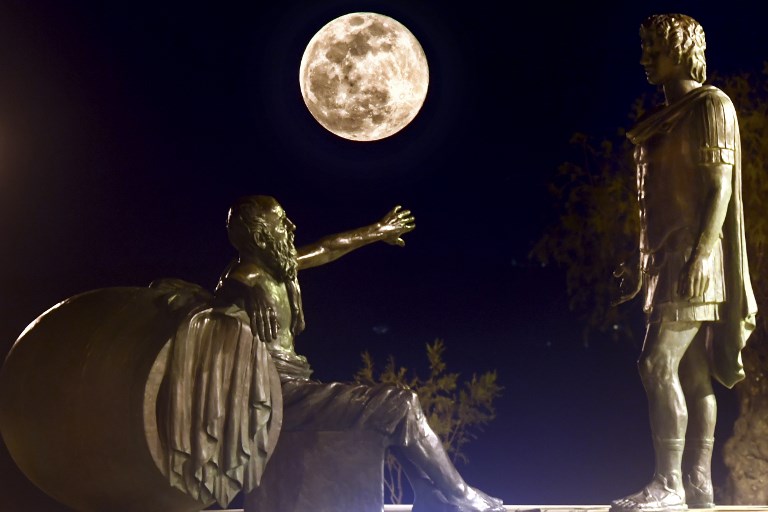 SUPER MOON. The Snow Moon rises between the statues of Alexander the Great (right) and Diogenes of Sinope in Corinth, Athens, Greece on February 19, 2019. Photo by Valerie Gache/AFP   