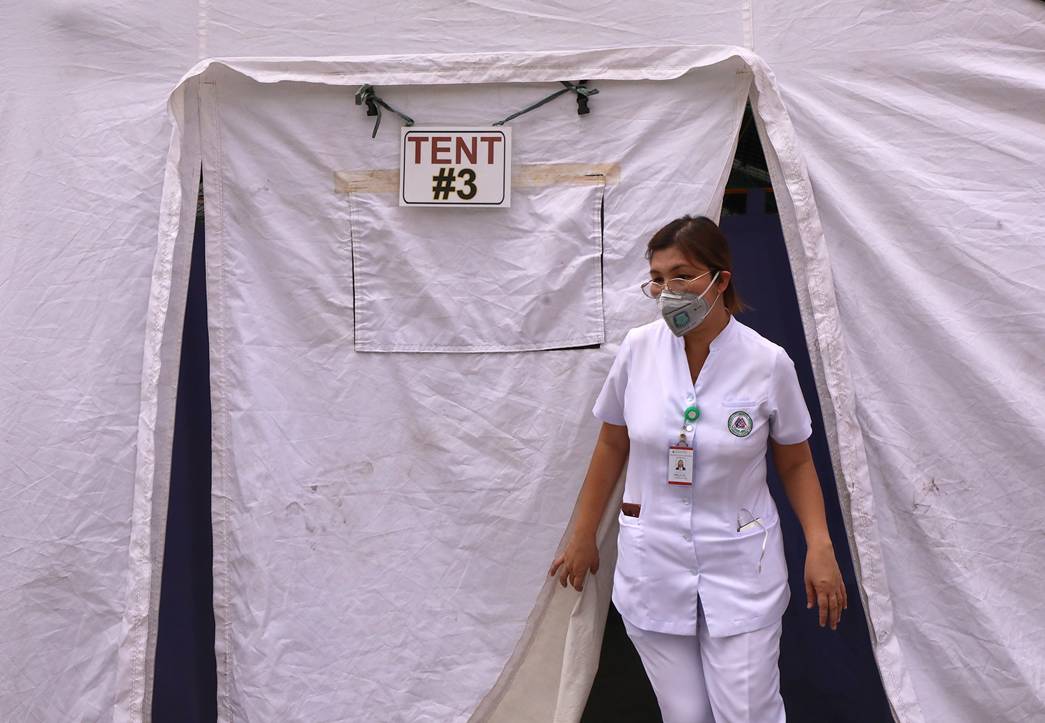PANDEMIC. A health worker at the Quezon City General Hospital prepares an solation tent for novel coronavirus patients on Tuesday, March 10, 2020. Photo by Darren Langit/Rappler 
