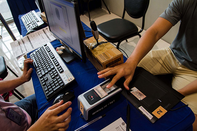 'NO BIO, NO BOTO.' An election officer takes a voter's biometric records during a satellite voter registration event in a mall on July 4. Mark Z. Saludes/Rappler 