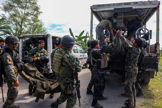 BODY BAGS. Members of the Special Action Force carry bodies of their comrades killed in Maguindanao on Sunday, January 25. Photo by Althea Ballentes/EPA
 