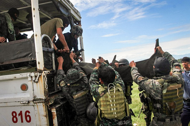 'MISENCOUNTER.' Philippine police commandos load body bags onto a truck in the town of Mamasapano, in Mindanao on January 26, 2015. Photo by Mark Navales/AFP  