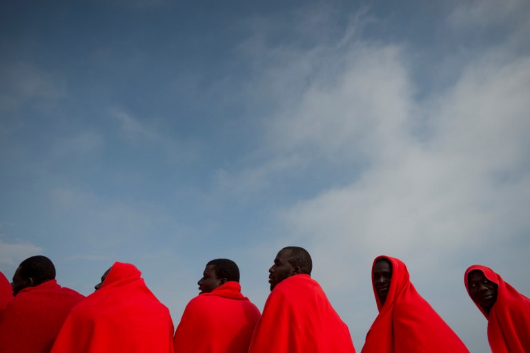 REFUGEES. Migrants keep warm in a Red Cross blanket after arriving aboard a coast guard boat at Malaga's harbour on April 26, 2018, after an inflatable boat carrying 80 men, 6 women and 4 child was rescued by the Spanish coast guard off the Spanish coast. Photo by Jorge Guerrero/AFP  