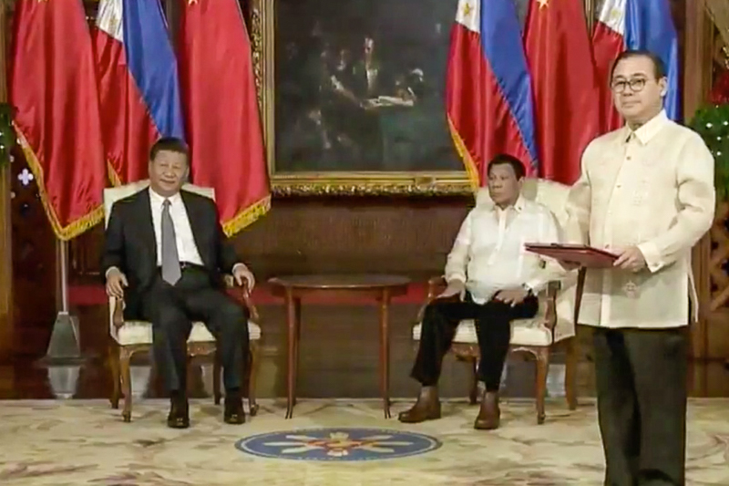 COOPERATING OIL EXPLORATION. DFA Secretary Teodoro Locsin Jr prepares to exchange the MOU on oil and gas development with Chinese Foreign Minister Wang Yi. Screengrab from RTVM 
