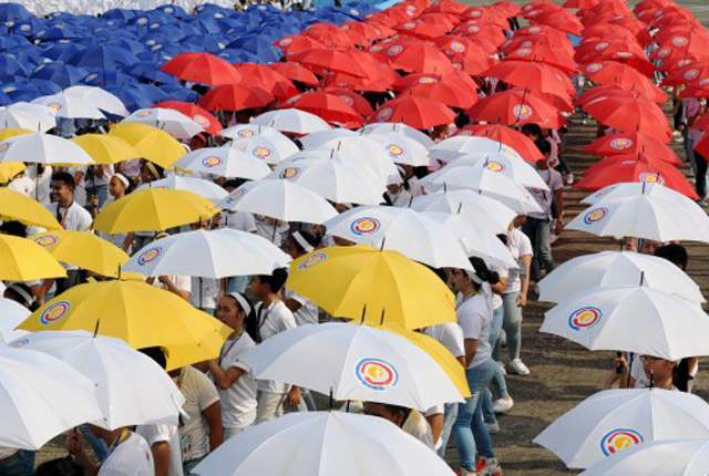 Students holding umbrellas rehearse a dance number hours prior to the arrival of Pope Francis at the Villamor Air base in Pasay City on January 15. Photo by Ted Aljibe/AFP