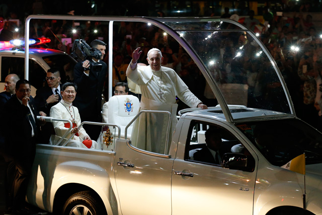 WHAT FILIPINOS SAW. On his way to the Apostolic Nunciature for his first night in the Philippines, Pope Francis riding on his 'popemobile' waves to well-wishers along a street in Manila on January 15, 2015.  