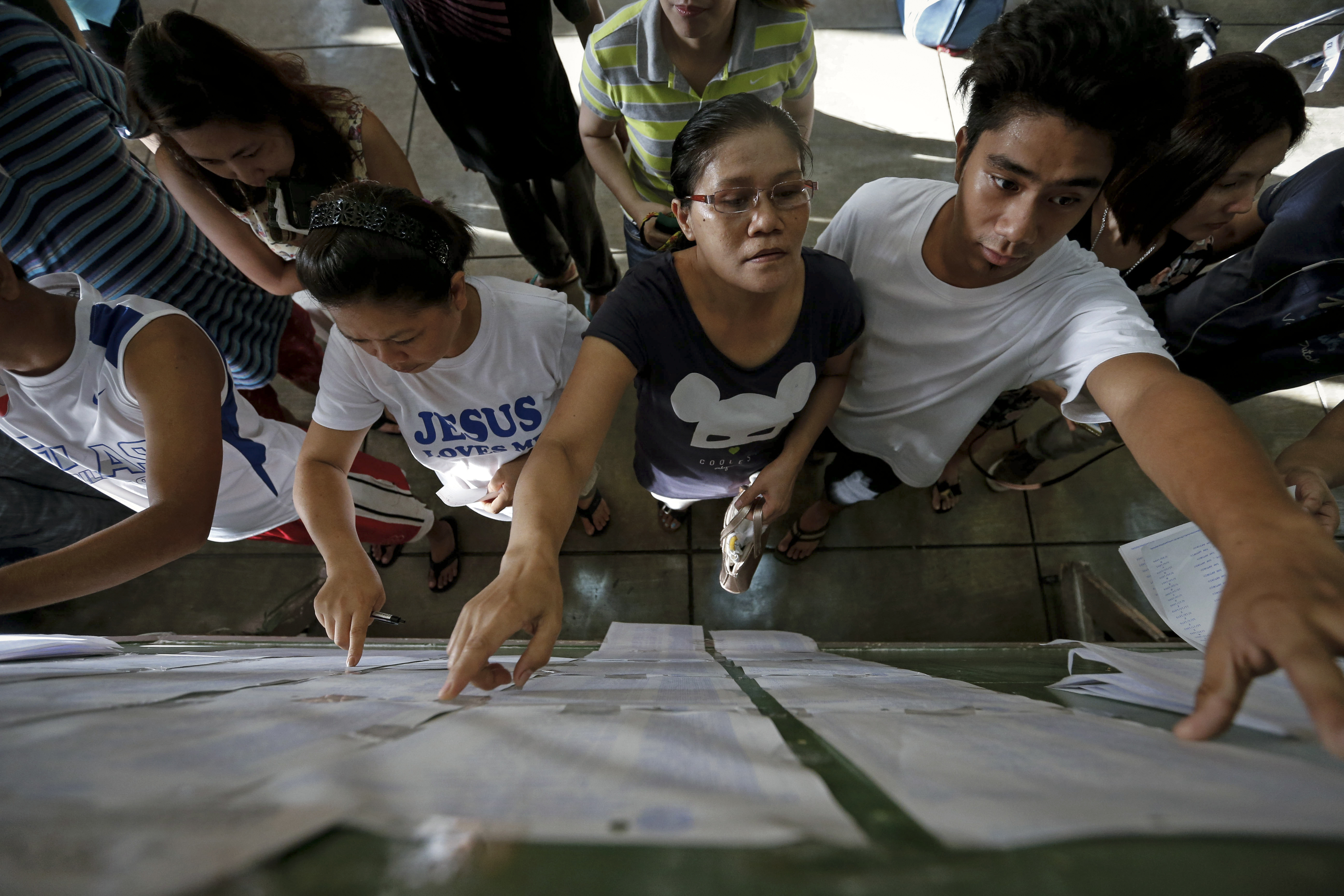 GREAT VOTER TURNOUT. Filipinos look for their names on the voters' list inside a polling precinct in Makati City, May 9, 2016. Photo by Mark R. Cristino/EPA 