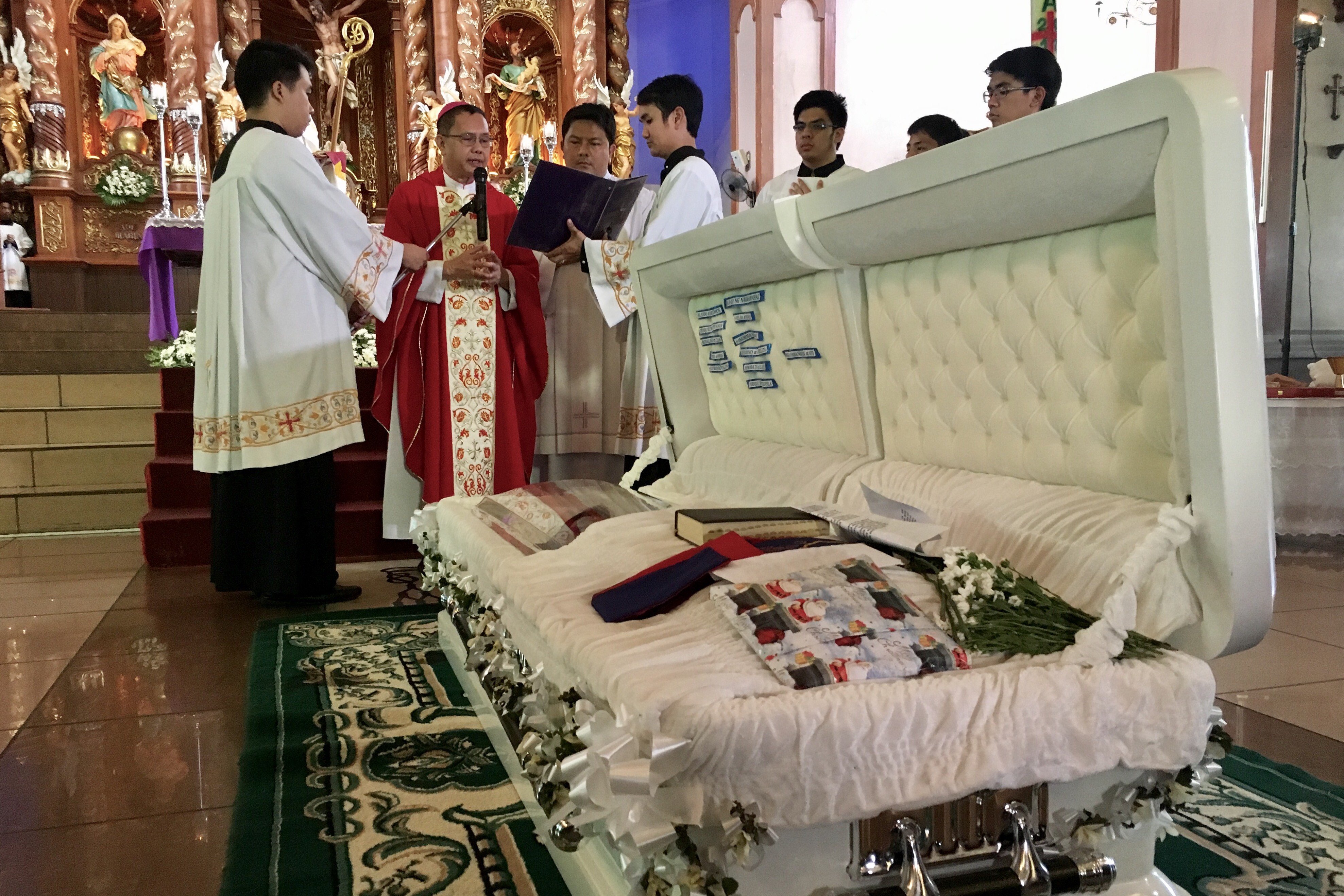 BISHOP of San Jose City Robert Mallari prays over the casket of Father Tito at the Saintt Joseph Cathedral