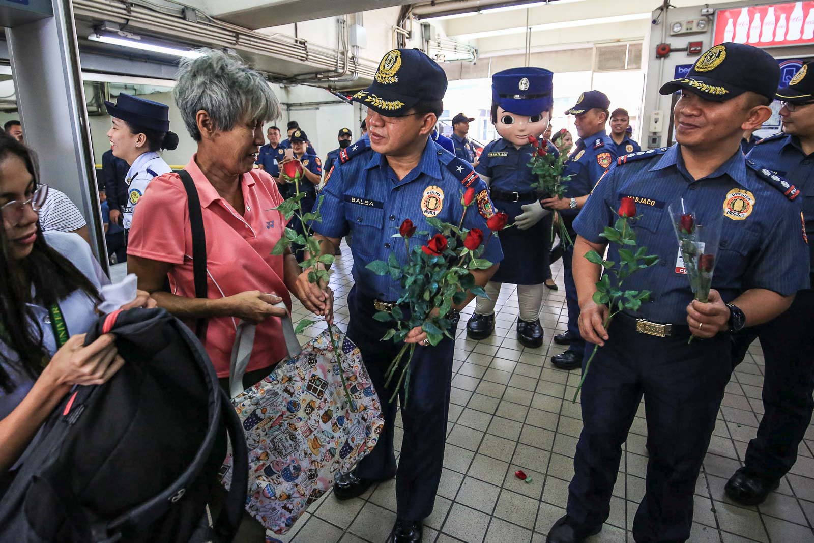 TRAIN ACCESS. Police give flowers to passengers of LRT Central Station in Arroceros, Manila, to celebrate Valentine's Day on February 14, 2020. File photo by Inoue Jaena/Rappler 