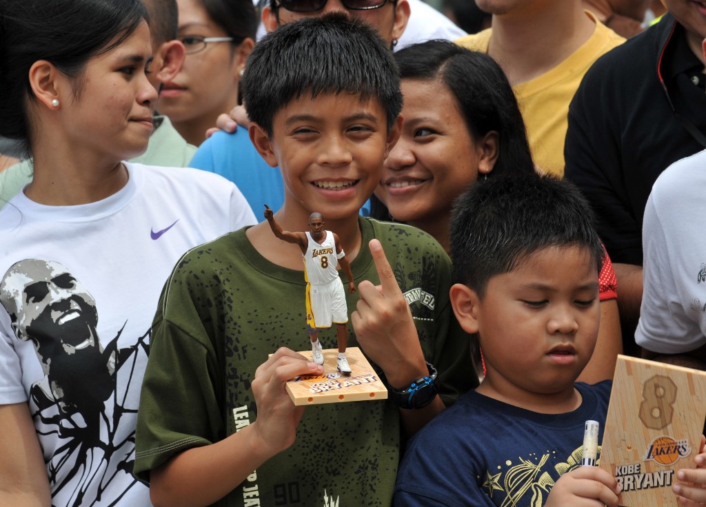 FAN BOY. A young Kobe Bryant fan holds up a figurine of the NBA superstar as supporters wait for his arrival at a Manila charity event on July 21, 2009. Photo by Ted Aljibe/AFP  