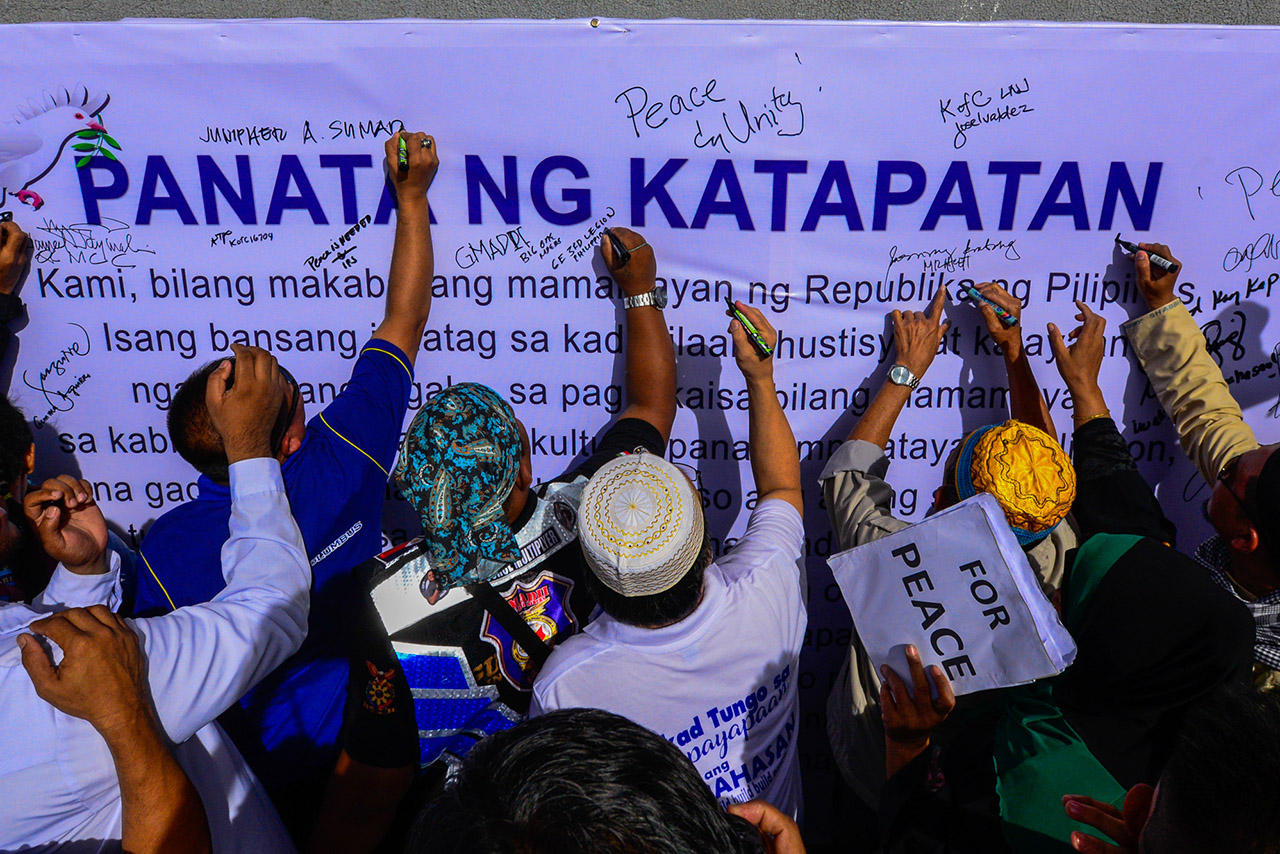 FOR PEACE. Muslims and Christians sign a unity pledge during the 'Lakad para sa Kapayapaan laban sa Karahasan' at the Quezon Memorial Circle in Quezon City on February 3, 2019. Photo by Maria Tan/Rappler   