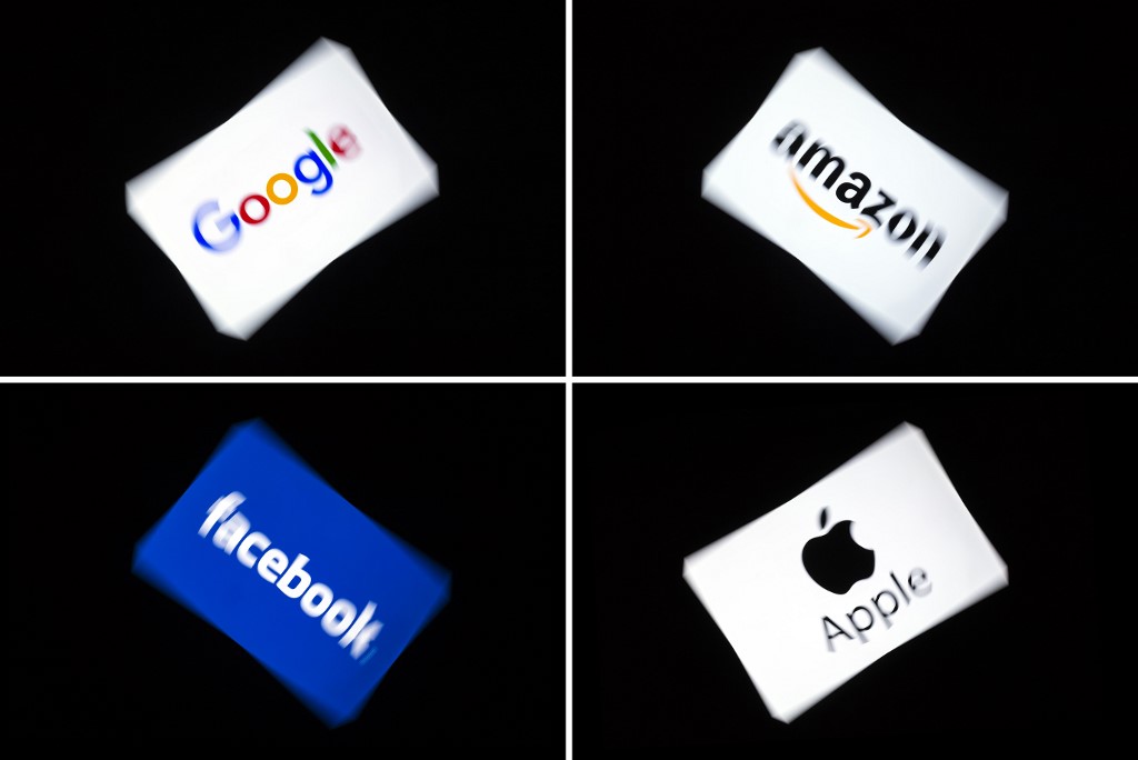 GAFA. This combination of pictures shows the logos of the GAFA's, named after US multinational technology and Internet-related services company Google, US online retail giant Amazon, US social media Facebook and US multinational technology company Apple, displayed on a tablet in Paris, on February 18, 2019. Photo by Lionel Bonaventure/AFP 