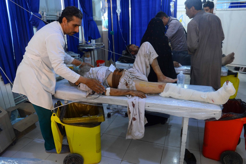 ROADSIDE BUS BOMBING. An Afghan man injured when a bus hit a roadside bomb on the Kandahar-Herat highway is treated by medical staff at a hospital in Herat on July 31, 2019. Photo by Hoshang Hashimi/AFP 