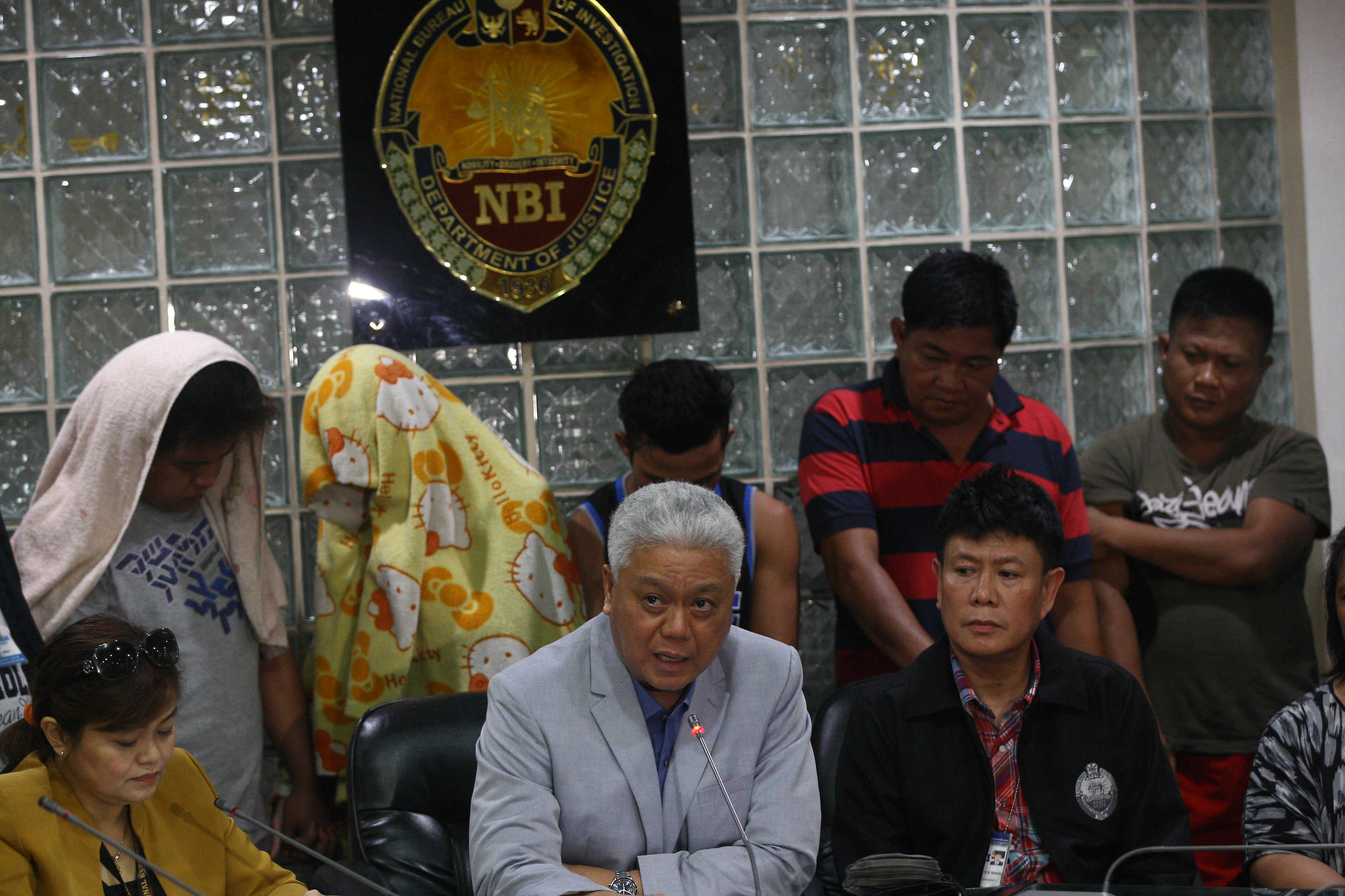 SUSPECTS. NBI spokesperson Ferdinand Lavin (seated, center) presents to the media on August 11, 2016, the 5 suspected human traffickers who were arrested in an entrapment operation. Photo by Ben Nabong/Rappler