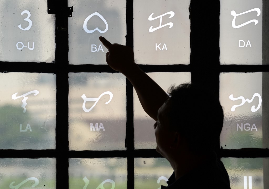 SYLLABLES. This photo taken on July 15, 2019 shows National Museum researcher Leo Batoon pointing to a Baybayin character etched on a glass window at the National Museum in Manila. Photo by Ted Aljibe/AFP 