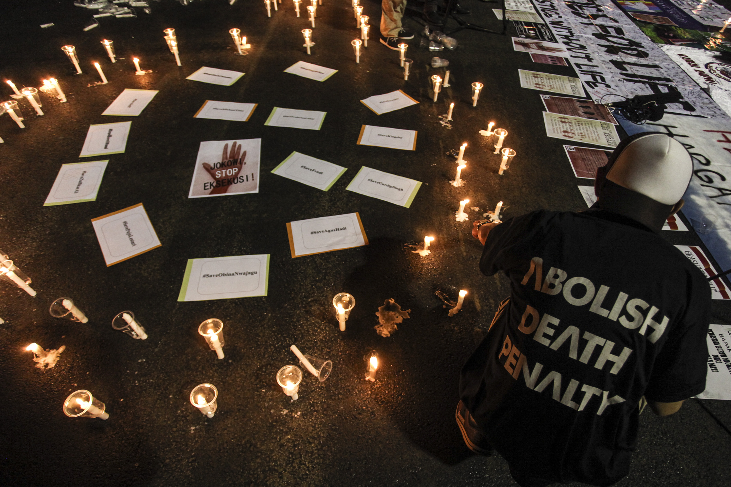 TOLAK HUKUMAN MATI. Aktivis yang tergabung dalam Lembaga Bantuan Hukum Masyarakat menyalakan lilin pada aksi Menolak Hukuman Mati jilid 3 di depan Istana Merdeka, Jakarta, Kamis, 28 Juli. Foto oleh Muhammad Adimaja/ANTARA  