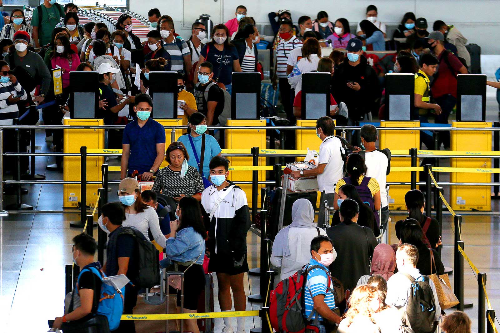 CORONAVIRUS. Passengers wearing face masks line up at the Ninoy Aquino International Airport Terminal 3 on March 13, 2020. Photo by Inoue Jaena/Rappler 