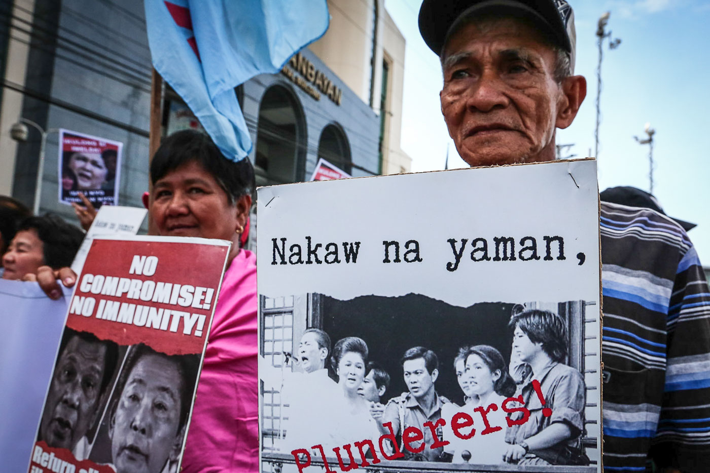 REMINDER. An elderly man holds up a photo of the late strongman Ferdinand Marcos and his family, tagged as 'plunderers' on November 16, 2018 