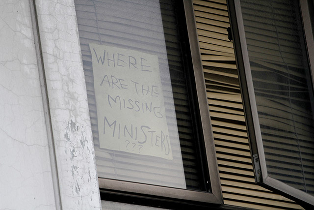 'MISSING MINISTERS.' Unidentified men post this message on July 23, 2015, on the window of the Iglesia ni Cristo building at 36 Tandang Sora St, Quezon City. Photo by Mark Saludes/Rappler  