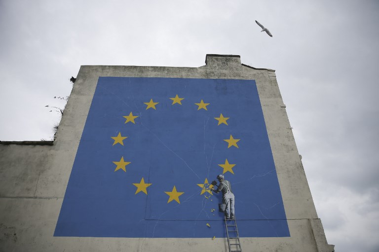 CHIPPING AWAY. A mural by British artist Banksy, depicting a workman chipping away at one of the stars on a European Union (EU) themed flag, is pictured in Dover, south east England on March 19, 2018. Photo by Daniel Leal-Olivas/AFP 