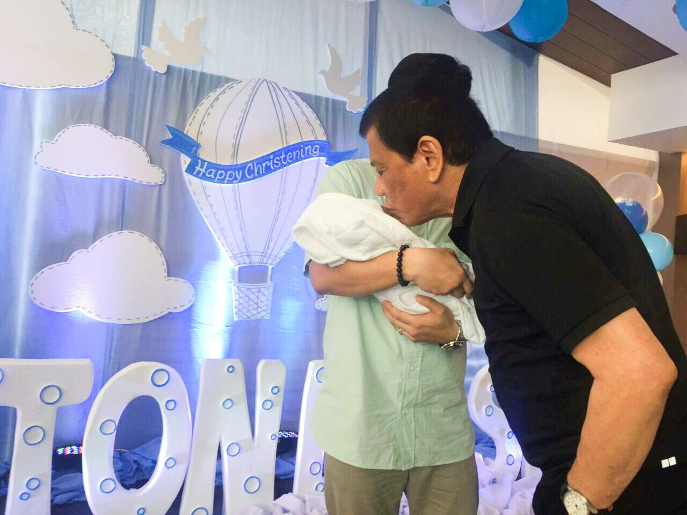 FAMILY TIME. President Rodrigo Duterte kisses grandson Stonefish Carpio during his baptism party. MPC pool photo  