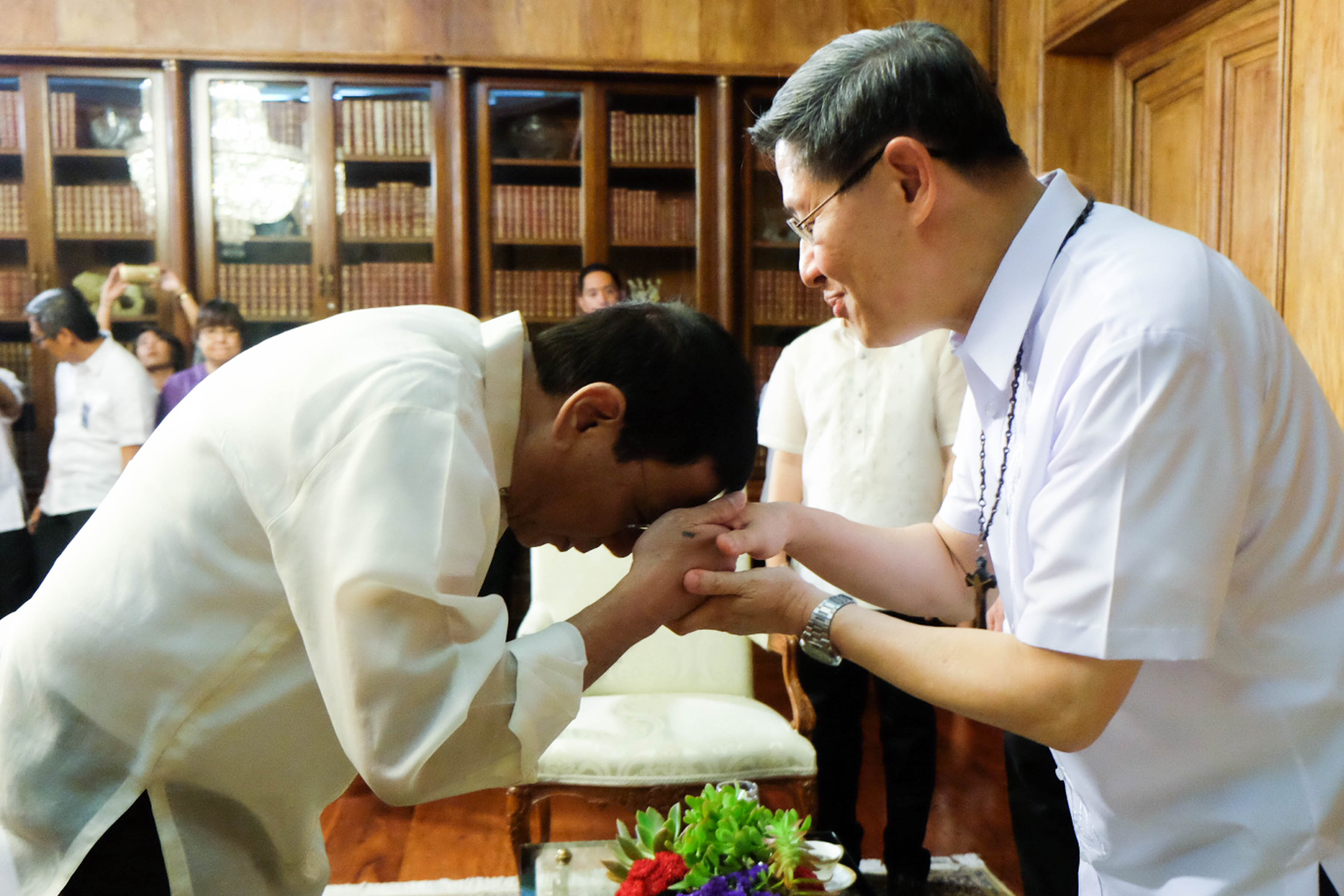 'MANO PO.' President Rodrigo Duterte places his forehead on Manila Archbishop Luis Antonio Cardinal Tagle's hand to show respect during a meeting at the Study Room of Malacañang Palace on July 19, 2016. File photo by Kiwi Bulaclac/PPD 