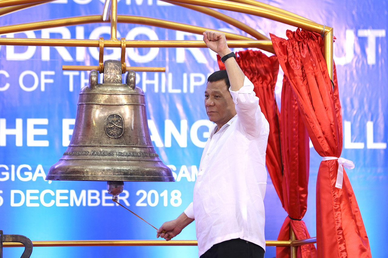 CLOSURE. President Rodrigo Duterte rings one of the Balangiga Bells after witnessing the official handover of its transfer certificate at the Balangiga Auditorium in Eastern Samar on December 15, 2018. Malacañang photo  