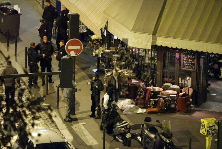 A victim lies on the ground covered by a white sheet outside of the Cafe Bonne Biere in Paris, on November 13, 2015 following an attack. Photo by Kenzo Tribouillard/AFP 