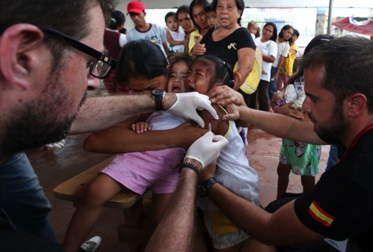 NO MAJOR OUTBREAKS. Spanish medical volunteer Manuel Pardo Rius (R), 33, and Pablo Carreno Tormo (L), 34, administer a measles vaccine to a young typhoon victim during the WHO-UNICEF vaccination program inside the damaged San Antonio church in the super typhoon devastated town of Basey, Samar province, Philippines, Nov 28, 2013. File photo by Dennis M. Sabangan/EPA
