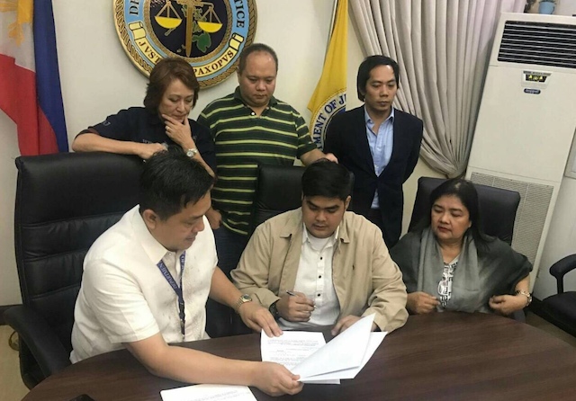 STATE WITNESS. Mark Ventura (middle) signs the document on his admission into the Witness Protection Program in connection with the case of hazing victim Horacio Castillo III. Photo courtesy of DOJ  