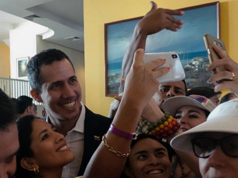 RETURNING. Venezuelan opposition leader and self-proclaimed acting president Juan Guaido (left) poses for a selfie picture with supporters at the lobby of a hotel in Salinas, Ecuador on March 3, 2019. Photo by Rodrigo Buendia/AFP 
