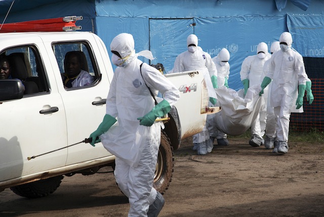 A photograph made available 27 July 2014 shows Liberian health workers in protective gear on the way to bury a woman who died of the Ebola virus from the isolation unit in Foya, Lofa County, Liberia, 02 July 2014. Ahmed Jallanzo/EPA