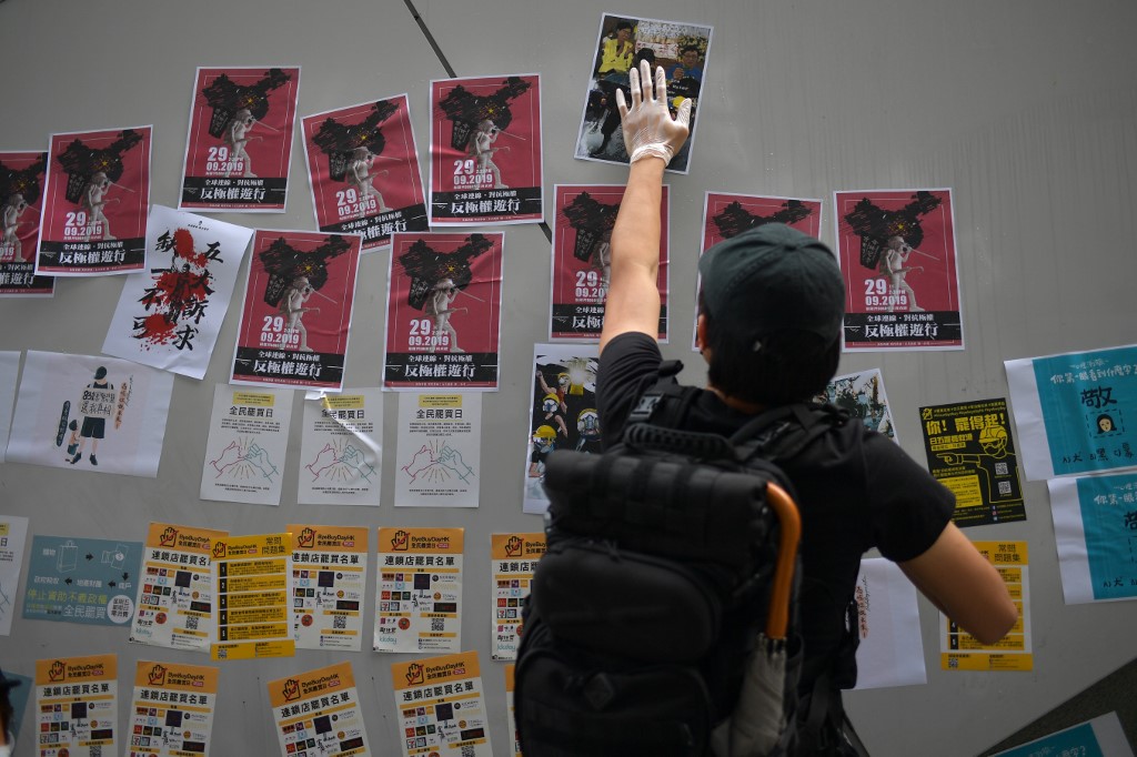 PROTEST. A man posts handbills and notes to help create a new "Lennon Wall" in the Admiralty area in Hong Kong on September 28, 2019, as activists mark the fifth anniversary of the "Umbrella Movement", a failed 79-day occupation that called for universal suffrage. Photo by Nicolas Asfouri/AFP  