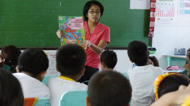 PASSION FOR LEARNING. Teacher Danna dela Cruz introduces a new book at Malaban Elementary School. Photo from TFP